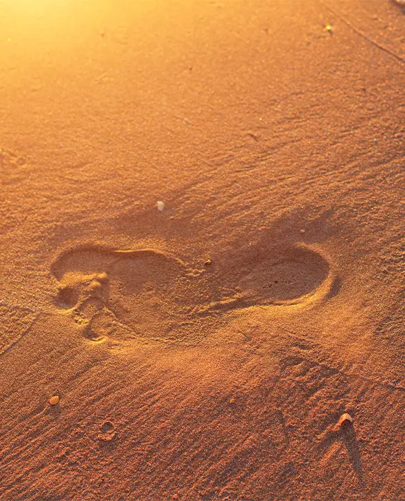 Een voet afdruk op het strand in het zand